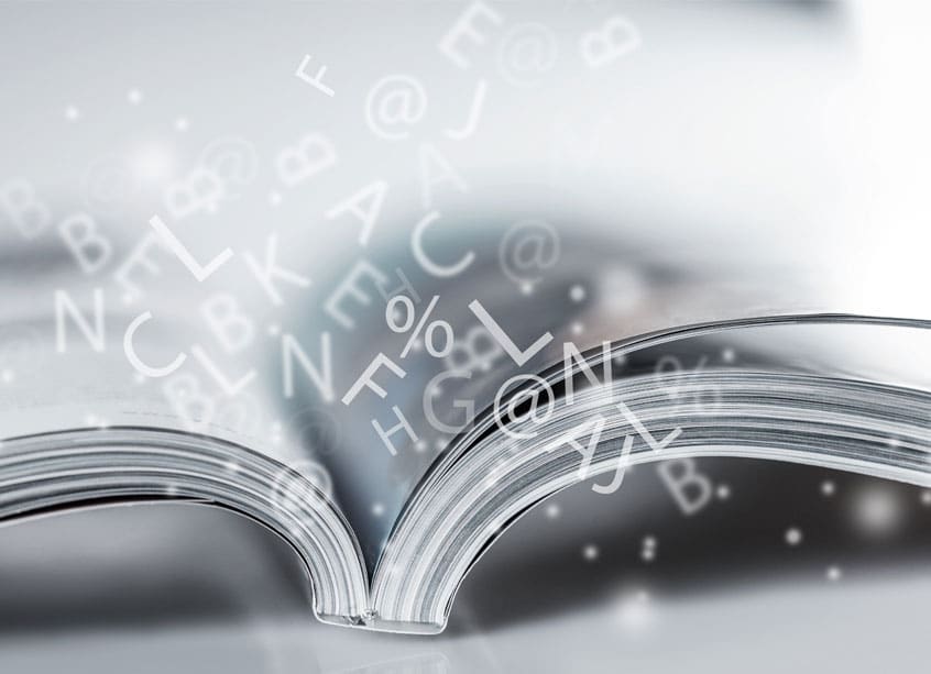 ein aufgeklapptes Magazin mit daraus springenden Buchstaben