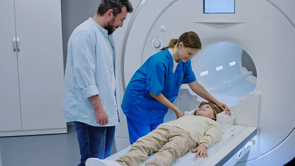 Kind liegt auf Liege und wird vorbereitet für einen MRT Scan